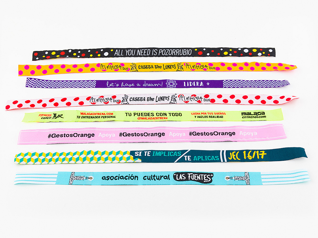 Ocho pulseras de tela personalizadas extendidas, con textos, logos y colores variados